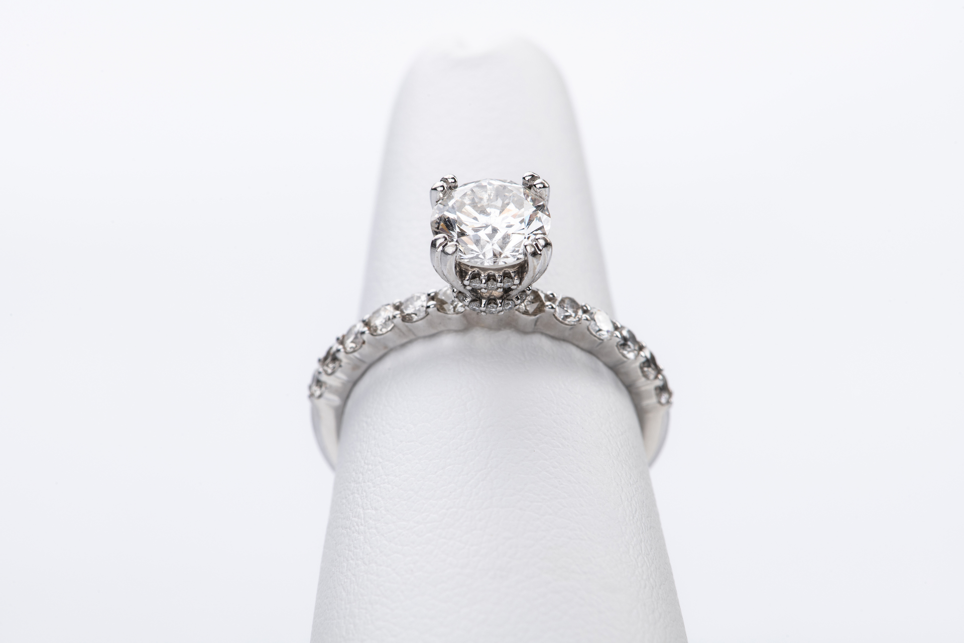 Diamond solitaire ring with a hidden halo on a pave band