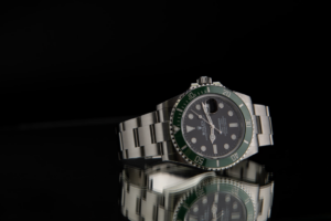 Rolex Kermit is shown here with its silver bracelet, black dial, and green bezel.