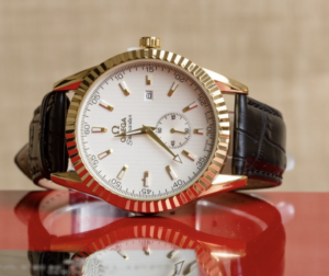 Omega watch with gold bezel, black strap, white dial 