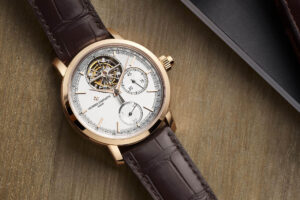 Tourbillon Watch with a white dial, gold bezel, and brown strap 