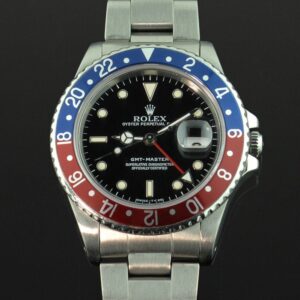 The Rolex GMT - "Pepsi" - is shown with its classic half blue, half red bezel, and black face, with the date to the right of the face. 